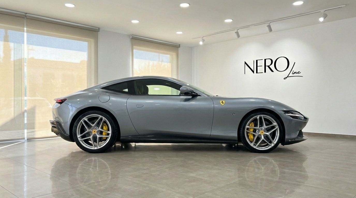 El elegante Ferrari Roma gris de 2022 se exhibe de perfil en un moderno showroom de NEROline en Madrid.
