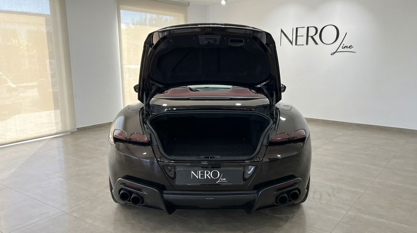 Vista posteriore della Ferrari Roma Spider nera metallizzata a Madrid, che mostra il bagagliaio aperto e il design elegante.