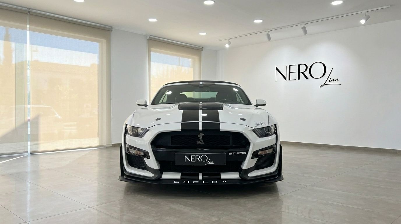 The white Ford Mustang 2.3 Convertible with black racing stripes is prominently displayed from a front view in a Benidorm showroom.