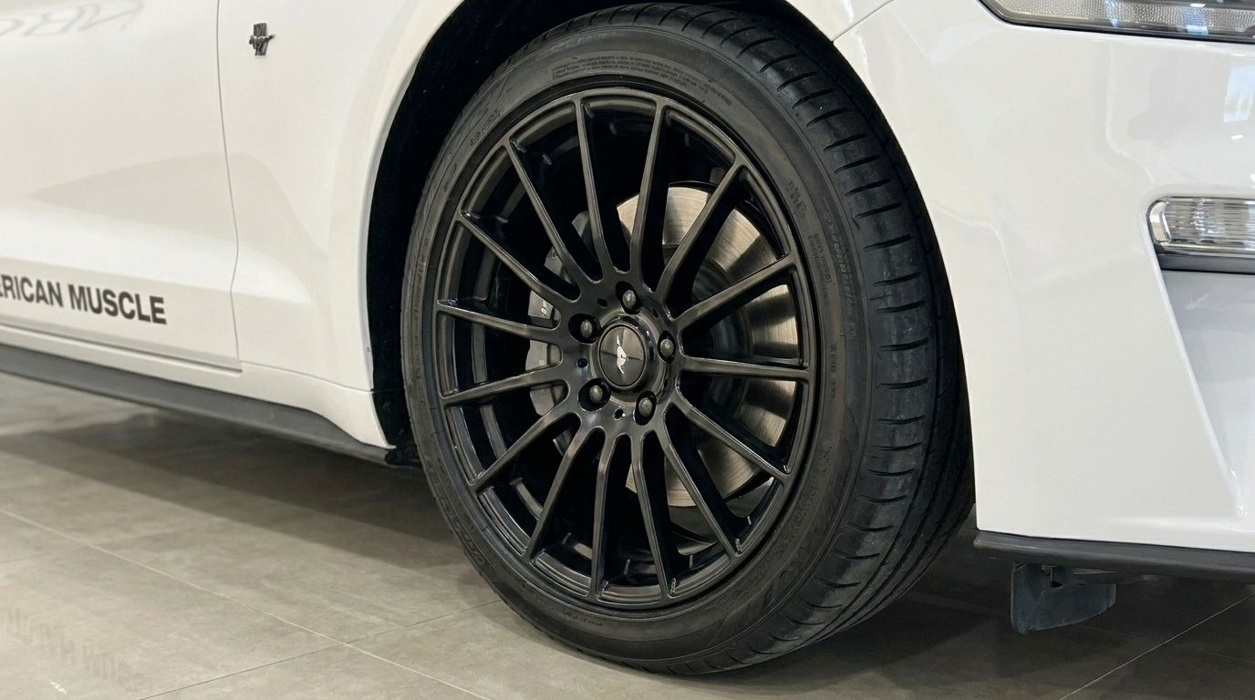 The sleek black multi-spoke wheel and white side profile of the Ford Mustang 2.3 Convertible in Benidorm.
