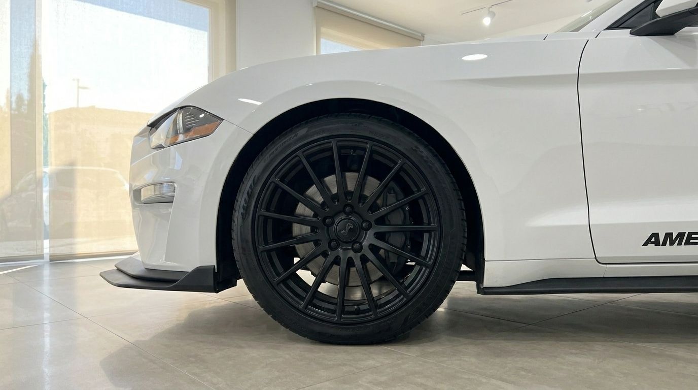 The gloss Oxford White Ford Mustang 2.3 EcoBoost Convertible's front-left wheel and fender are prominently displayed in Benidorm.