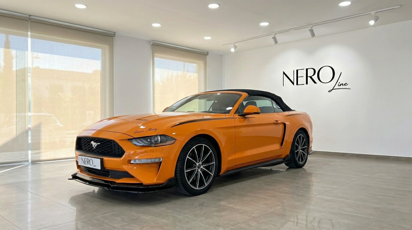 Ford Mustang 2.3 EcoBoost Convertible — Showroom view The orange Ford Mustang 2.3 EcoBoost Convertible is displayed in a showroom, viewed from the front three-quarter angle in Alicante.