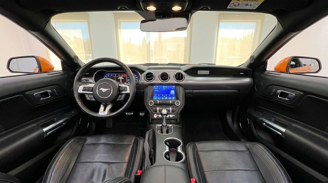 The interior of the Ford Mustang 2.3 EcoBoost Convertible in Alicante, featuring the dashboard, steering wheel, and black leather seats.