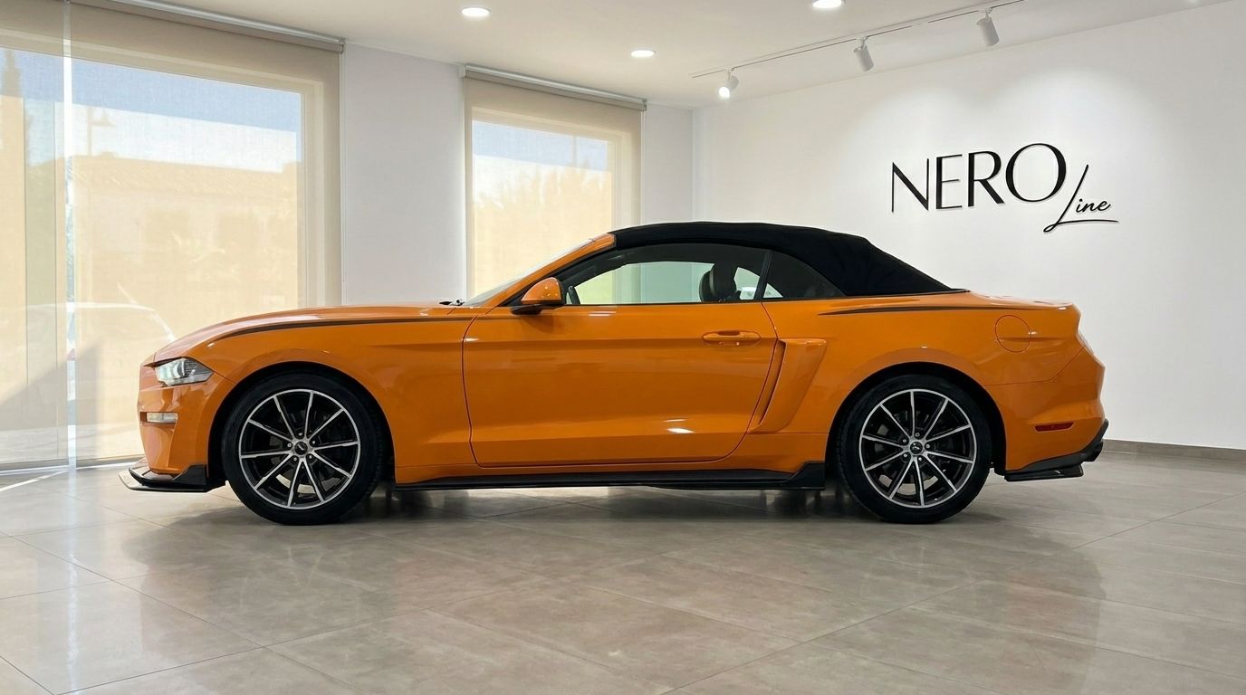 Orange Ford Mustang 2.3 EcoBoost Convertible with its black soft top up, shown in a side profile view indoors in Alicante.