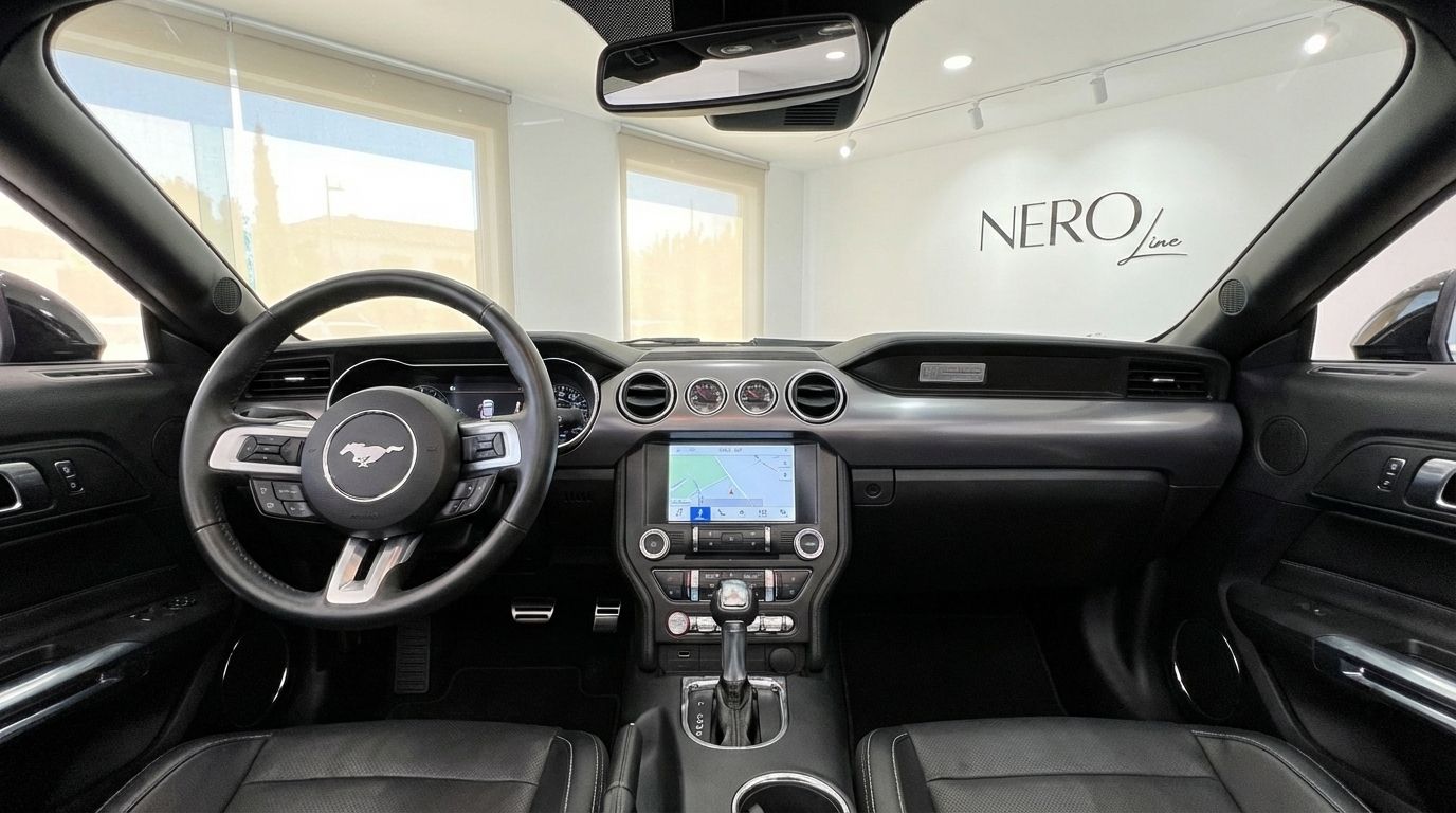 The luxurious black interior and dashboard of the Ford Mustang GT Convertible, featuring the steering wheel and central console in Barcelona.