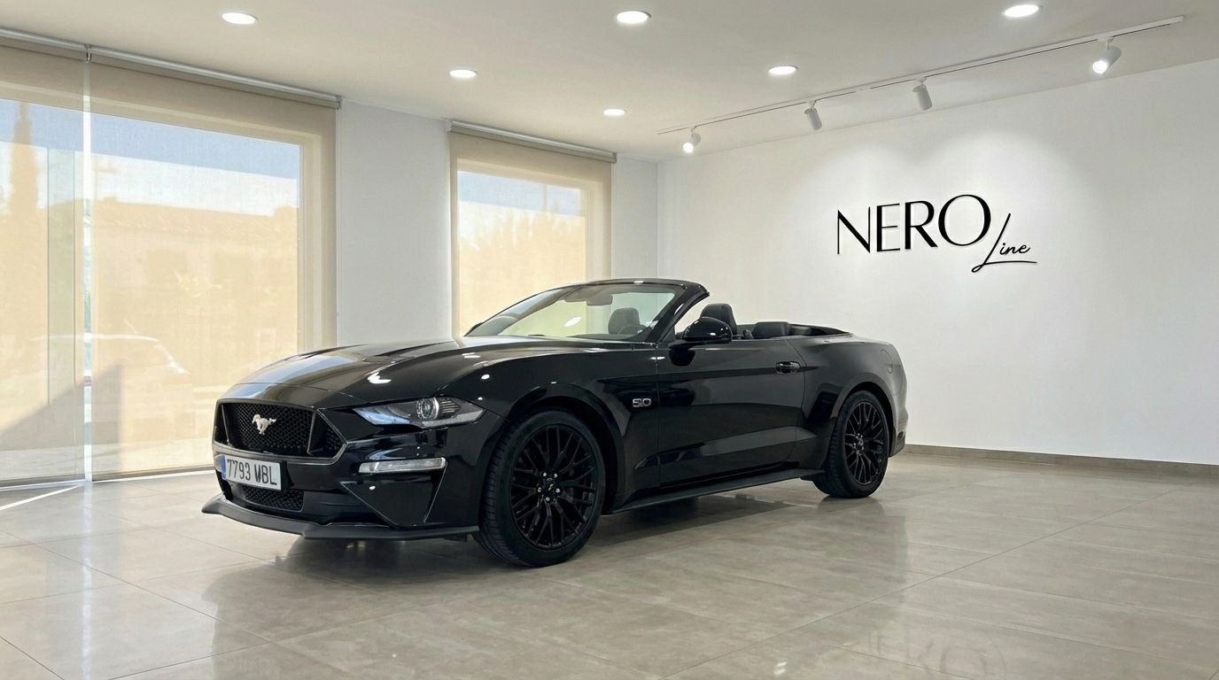 The black Ford Mustang GT Convertible with its top down is showcased in a modern showroom in Barcelona.