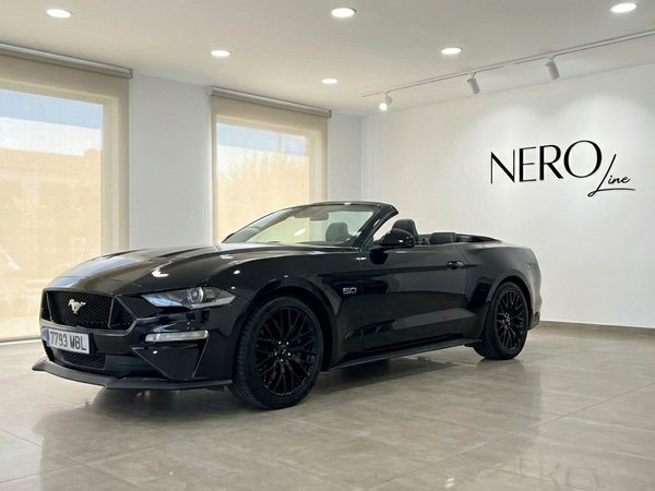 Ford Mustang GT Convertible — Showroom Barcelona The black Ford Mustang GT Convertible with its top down is showcased in a modern showroom in Barcelona.