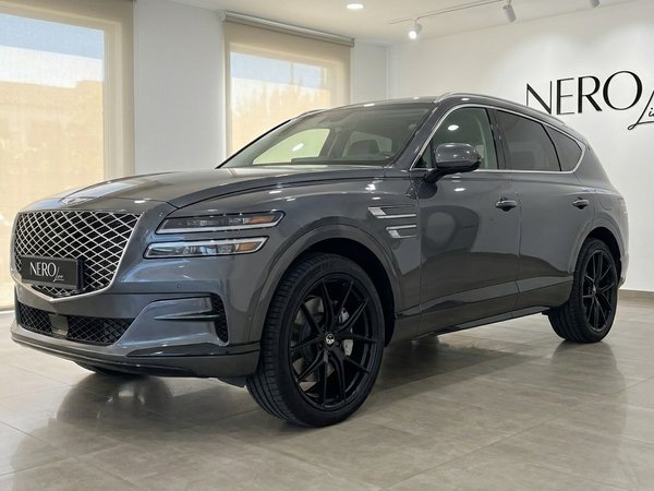 Genesis GV80 — Elegant SUV in Alicante Showroom The dark grey Genesis GV80 luxury SUV is displayed in a showroom, showcasing its elegant front three-quarter view with black wheels in Alicante.