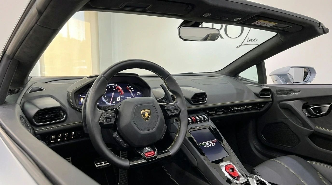 The luxurious interior cockpit of the Lamborghini Huracan Evo Spyder in matte gray, featuring the steering wheel and central console, available for rent in Ibiza.