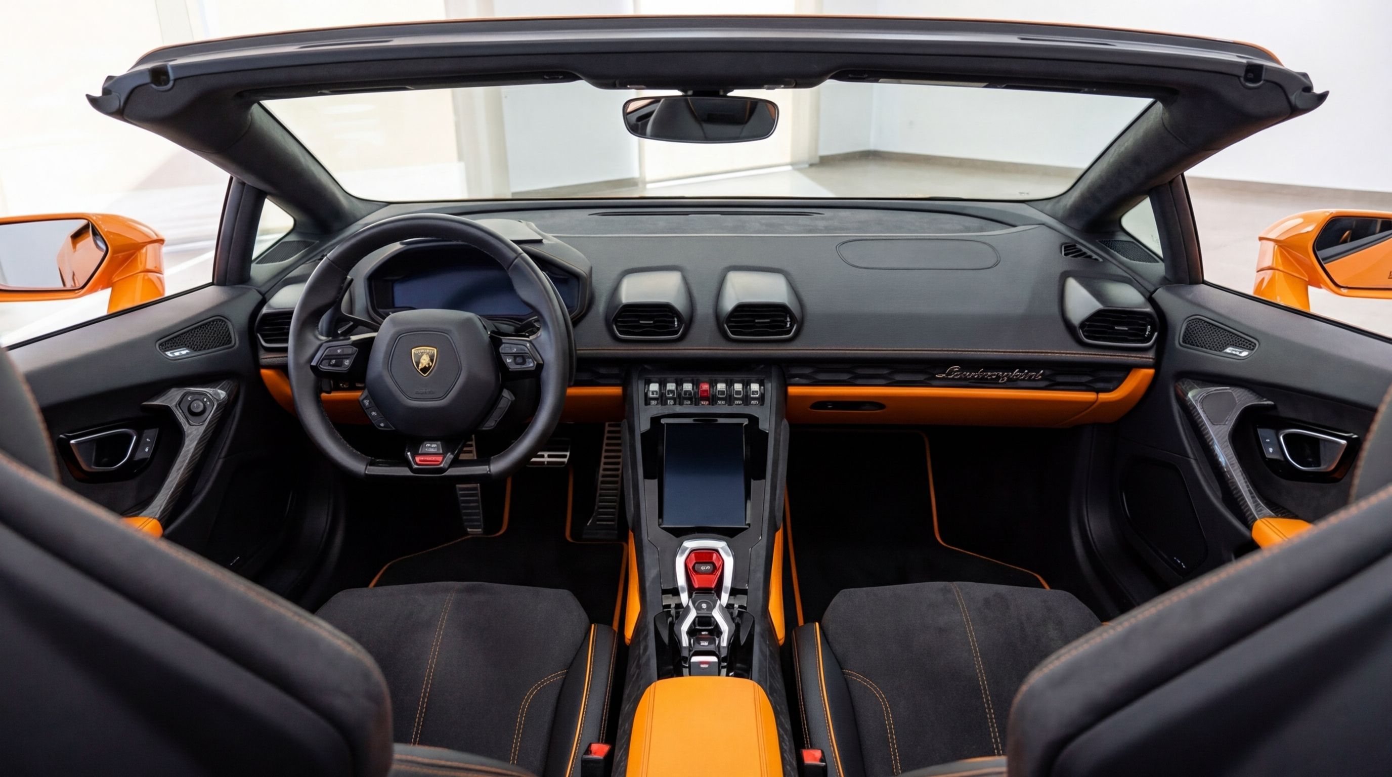 The luxurious black and vibrant orange cockpit and dashboard of the Lamborghini Huracan Evo Spyder in Malaga.