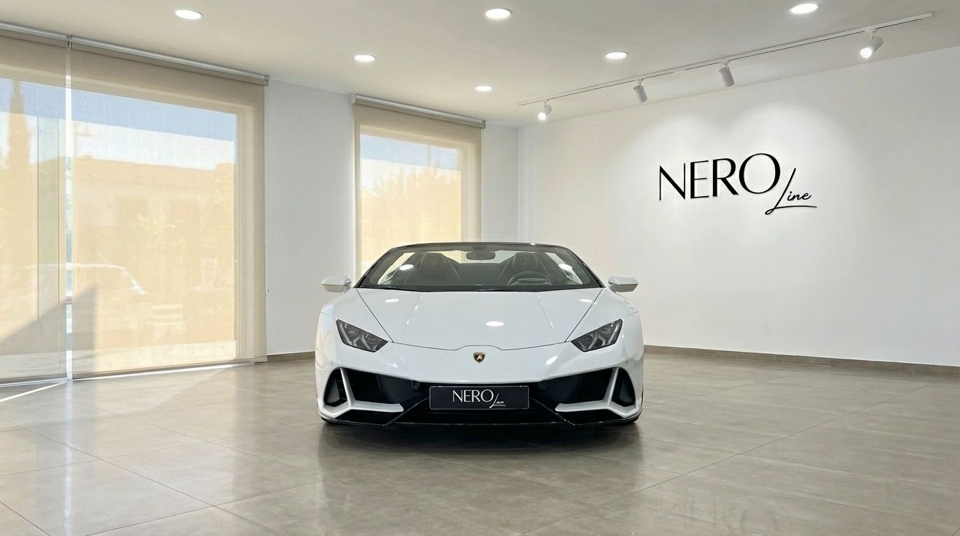 The white Lamborghini Huracan Evo Spyder is prominently displayed from the front in a bright studio showroom in Alicante.