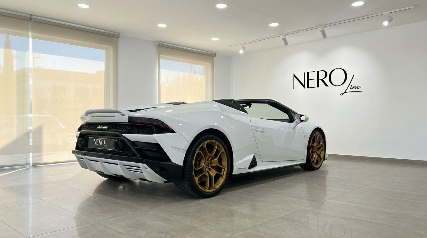 The white Lamborghini Huracan Evo Spyder with striking gold wheels is elegantly displayed in a showroom in Alicante.