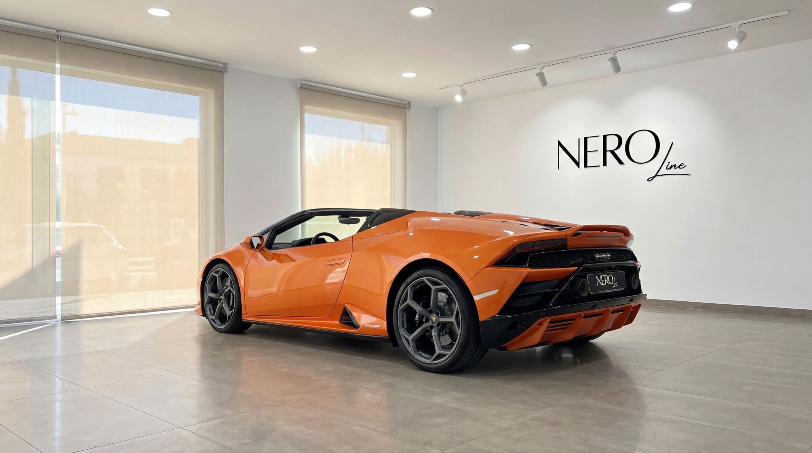 The vibrant orange Lamborghini Huracan Evo Spyder convertible, seen from the rear three-quarter angle, is parked in a showroom in Malaga.