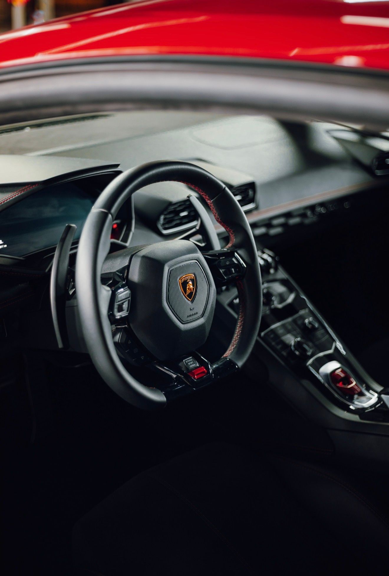 El interior del Lamborghini Huracan LP610-4 en Madrid, mostrando el volante con costuras rojas y el salpicadero.