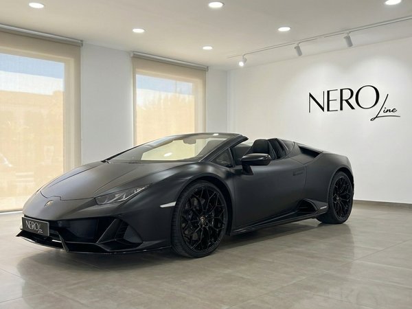 Lamborghini Huracan Spyder — Vista showroom Marbella La Lamborghini Huracan Spyder nera opaca è esposta in una vista tre quarti anteriore all'interno di uno showroom a Marbella.