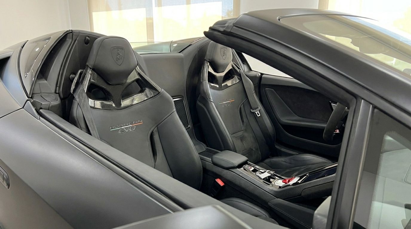 Das luxuriöse schwarze Lederinterieur und die Sportsitze aus Kohlefaser des Lamborghini Huracan Spyder in Marbella sind prominent dargestellt.