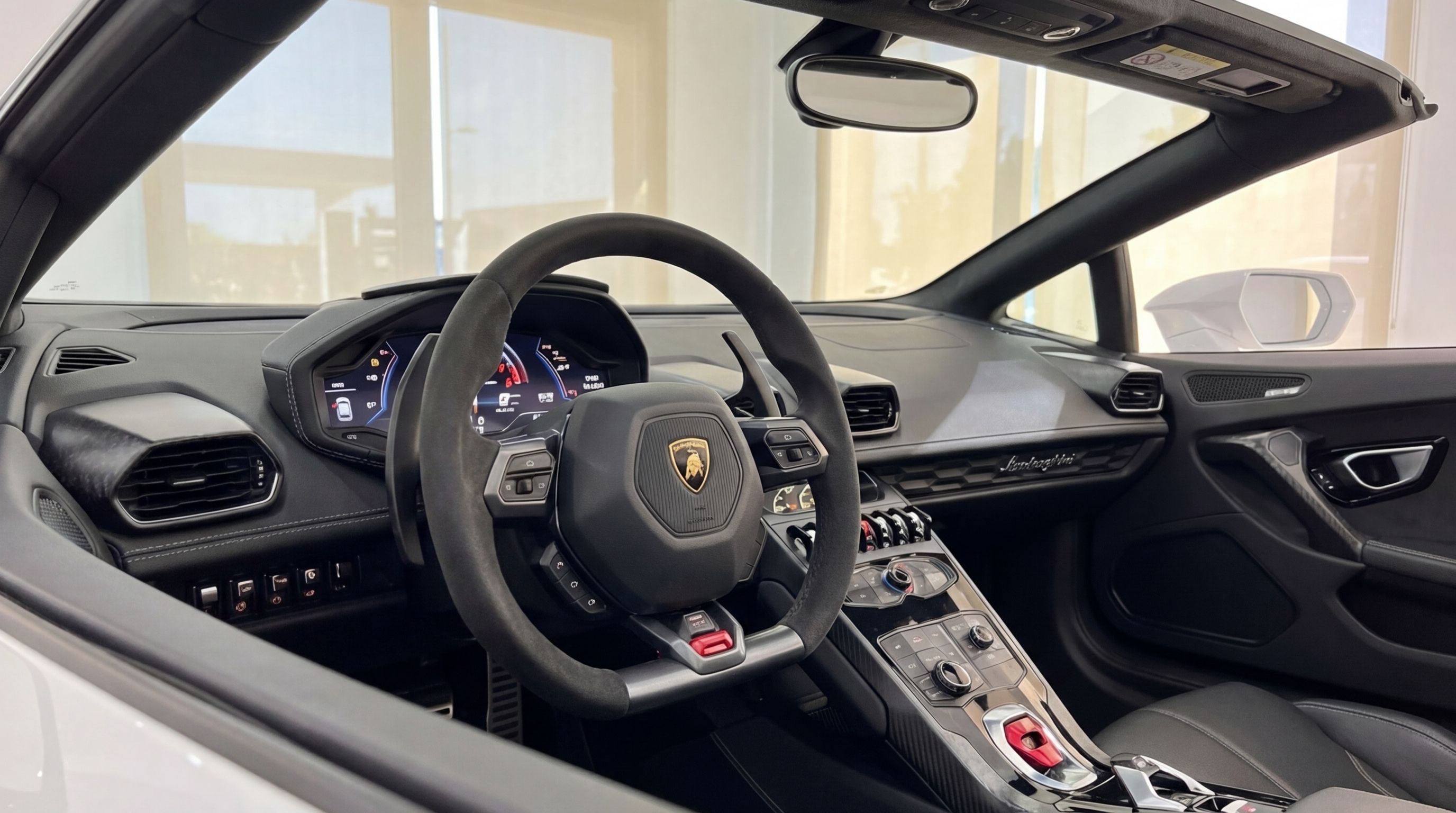 The luxurious cockpit of the white Lamborghini Huracan Spyder in Valencia, featuring the steering wheel, dashboard, and central console.