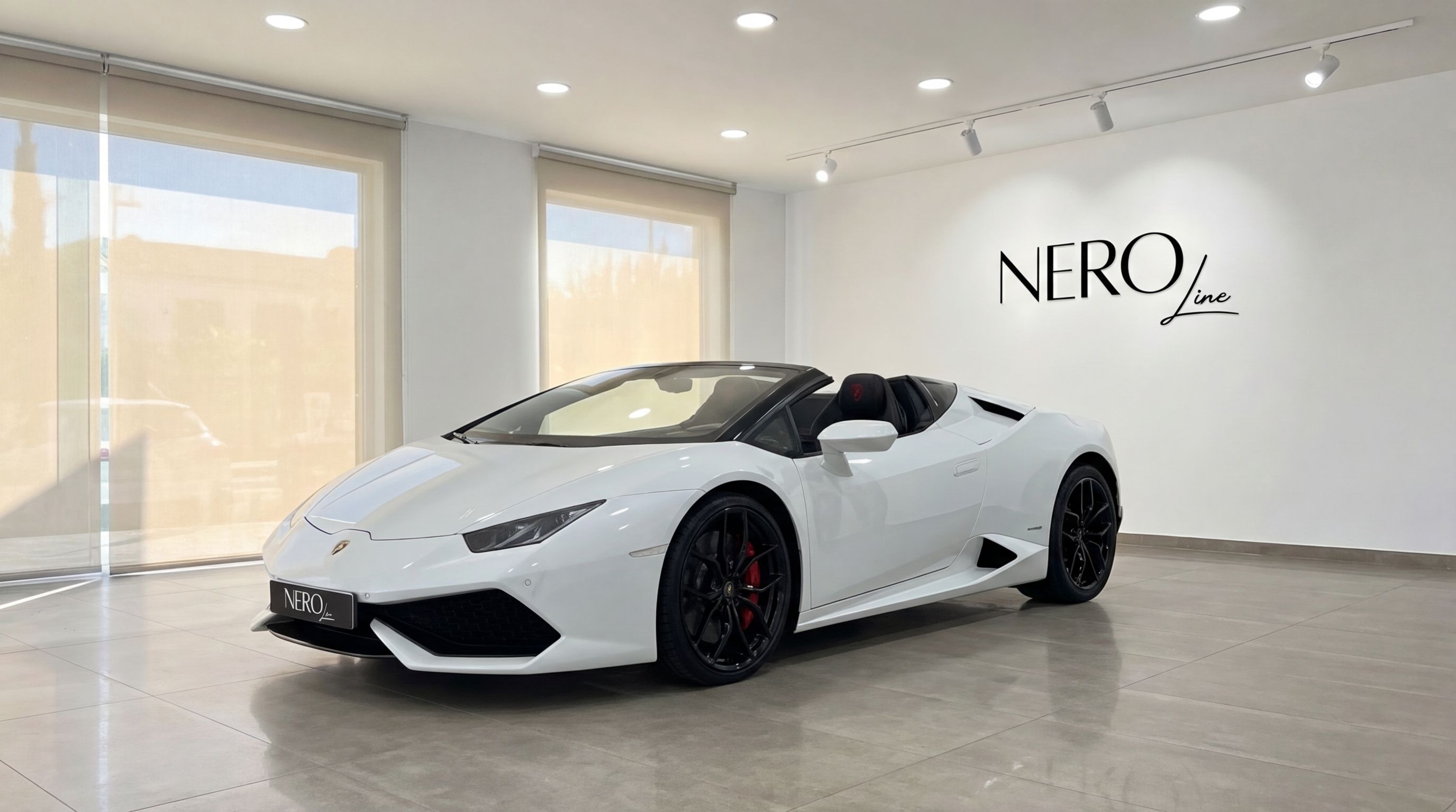 The white Lamborghini Huracan Spyder convertible is showcased from a front three-quarter view inside a modern showroom in Valencia.