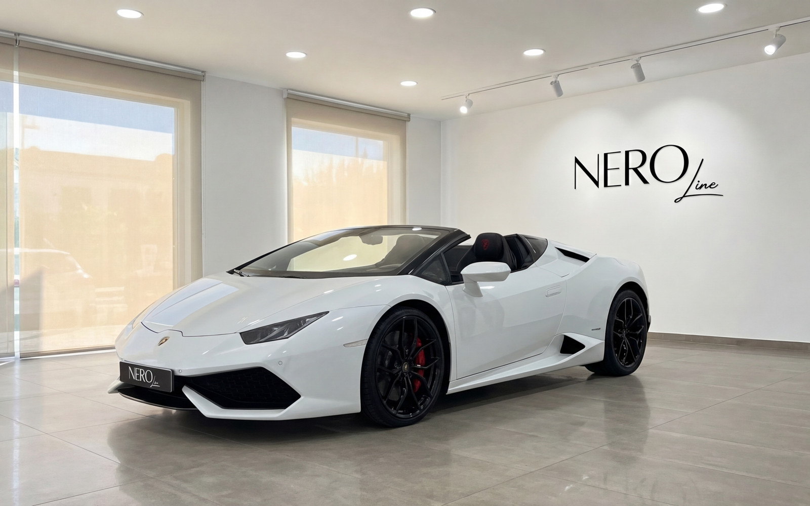 Lamborghini Huracan Spyder — Showroom in Valencia The white Lamborghini Huracan Spyder convertible is showcased from a front three-quarter view inside a modern showroom in Valencia.