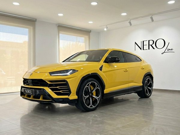 Lamborghini Urus — Front three-quarter view Marbella A striking Gloss Yellow Lamborghini Urus is showcased in a front three-quarter view within a modern showroom in Marbella.