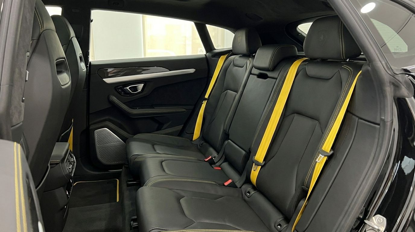 The black leather rear seats with vibrant yellow seatbelts and stitching in the Lamborghini Urus, available in Alicante.