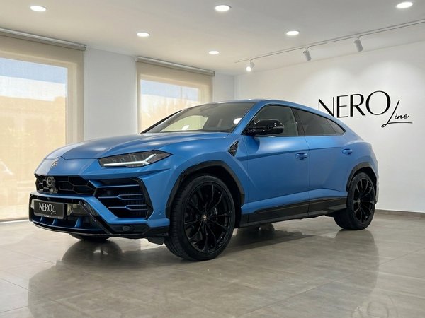 Lamborghini Urus S — Exterior frontal en Madrid El Lamborghini Urus S azul de 2020 está aparcado en un concesionario de Madrid, mostrando su elegante exterior frontal tres cuartos.