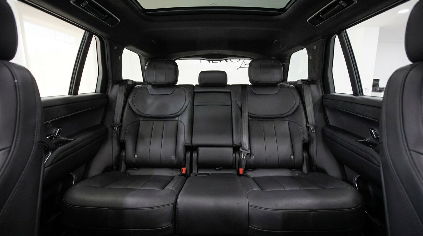 Se aprecian los lujosos asientos traseros de cuero negro y el espacioso interior del Land Rover Range Rover Sport en Madrid.