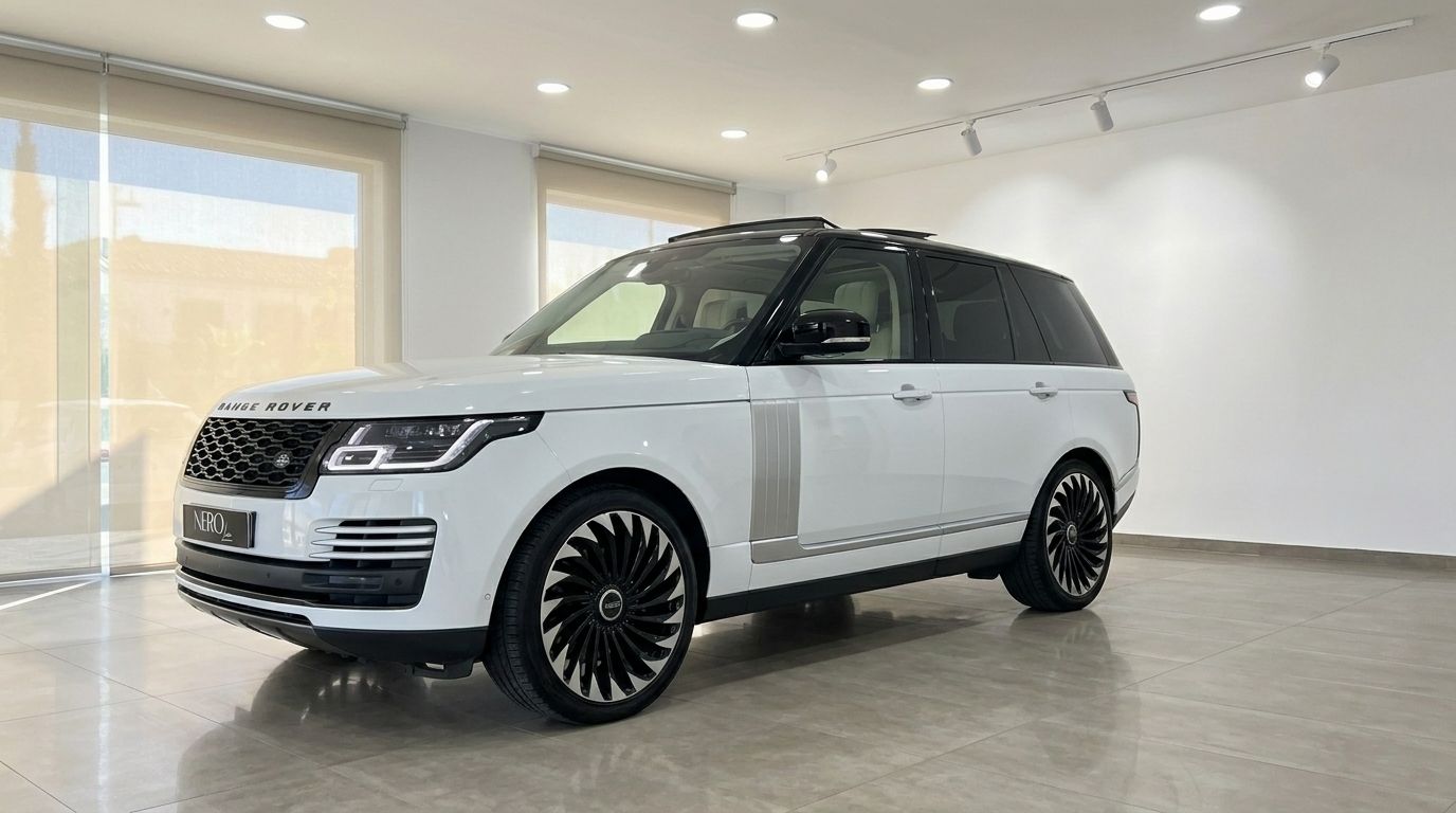 The white 2021 Land Rover Range Rover Vogue is showcased from a front three-quarter angle in a showroom in Alicante.