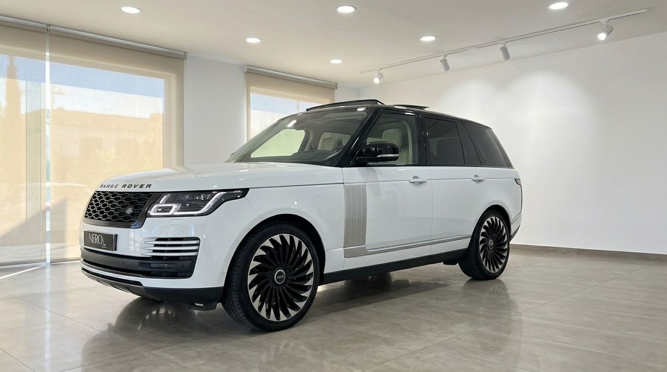 Land Rover Range Rover Vogue — Front view Alicante The white 2021 Land Rover Range Rover Vogue is showcased from a front three-quarter angle in a showroom in Alicante.
