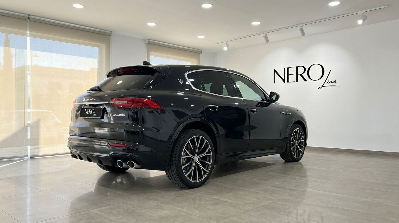 The gloss black 2024 Maserati Grecale is shown from a rear three-quarter angle inside a showroom in Marbella.