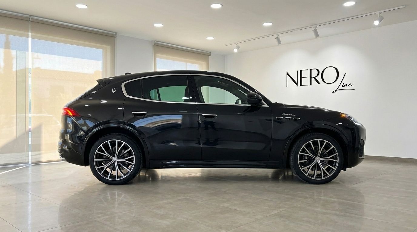 The 2024 Maserati Grecale in gloss black is showcased from its sleek side profile in a modern showroom in Marbella.