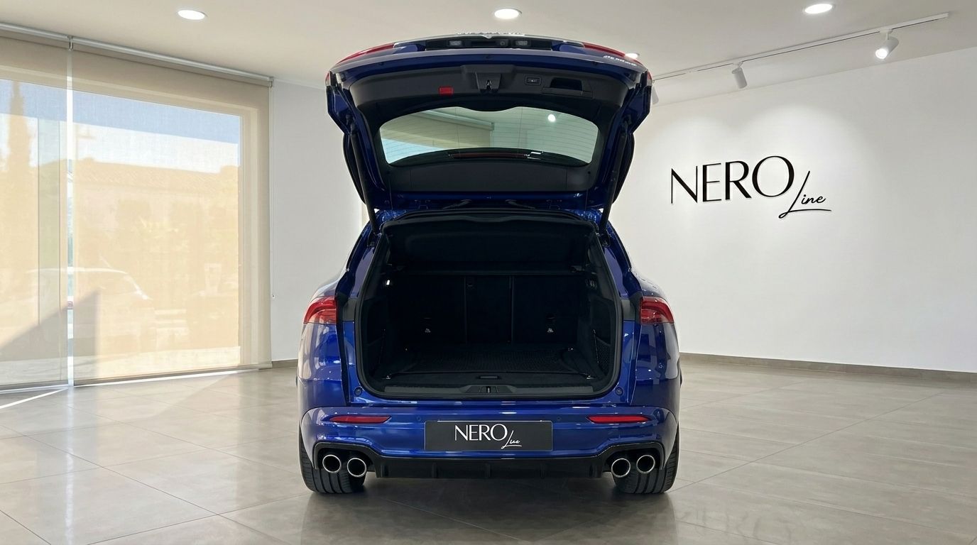 The metallic blue Maserati Grecale 2026 is shown from the rear with its trunk open in a Benidorm showroom.