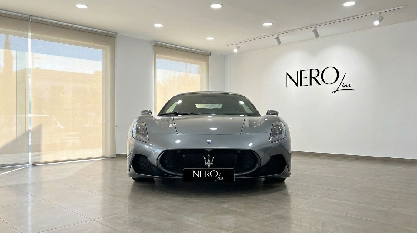 El supercoche Maserati MC20 gris metálico se exhibe prominentemente de frente en un luminoso showroom de Madrid.