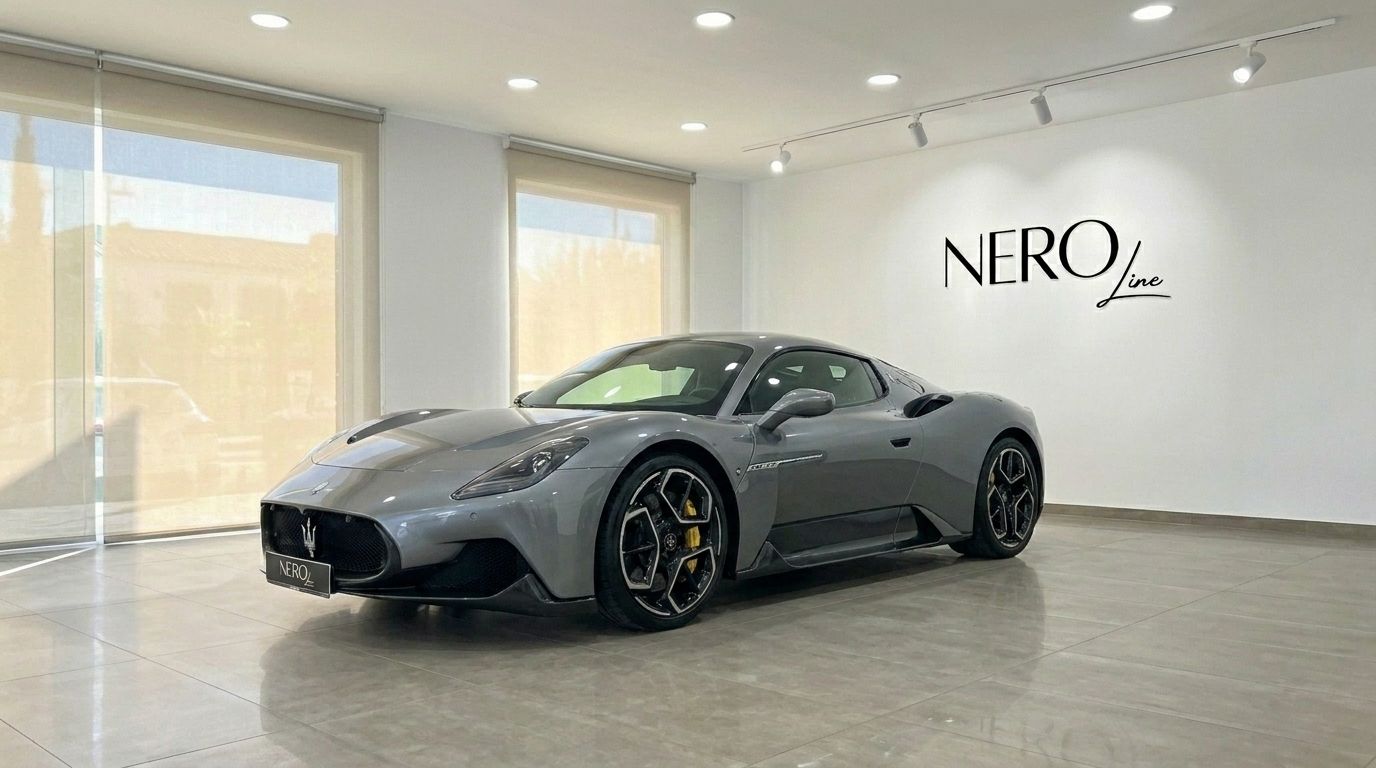 El supercoche Maserati MC20 gris metalizado se exhibe desde un ángulo frontal tres cuartos dentro de un moderno showroom de Nero Line en Madrid.