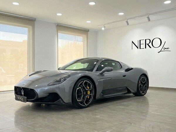 Maserati MC20 — Supercoche gris metalizado en Madrid El supercoche Maserati MC20 gris metalizado se exhibe desde un ángulo frontal tres cuartos dentro de un moderno showroom de Nero Line en Madrid.