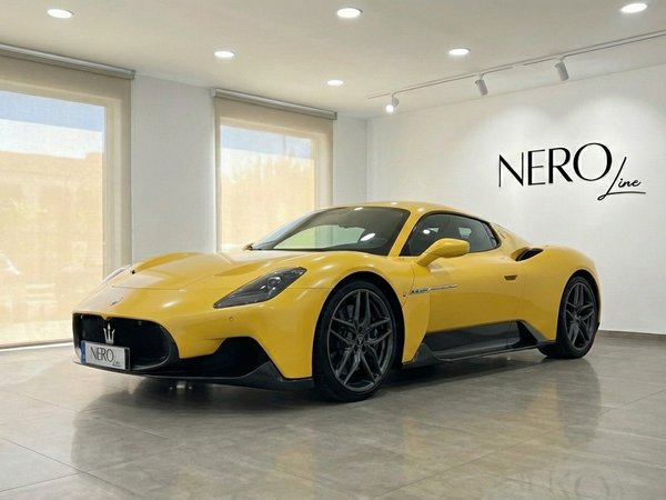 Maserati MC20 — Luxury Supercar in Valencia A vibrant yellow Maserati MC20 supercar is displayed from a front three-quarter angle inside a showroom in Valencia.