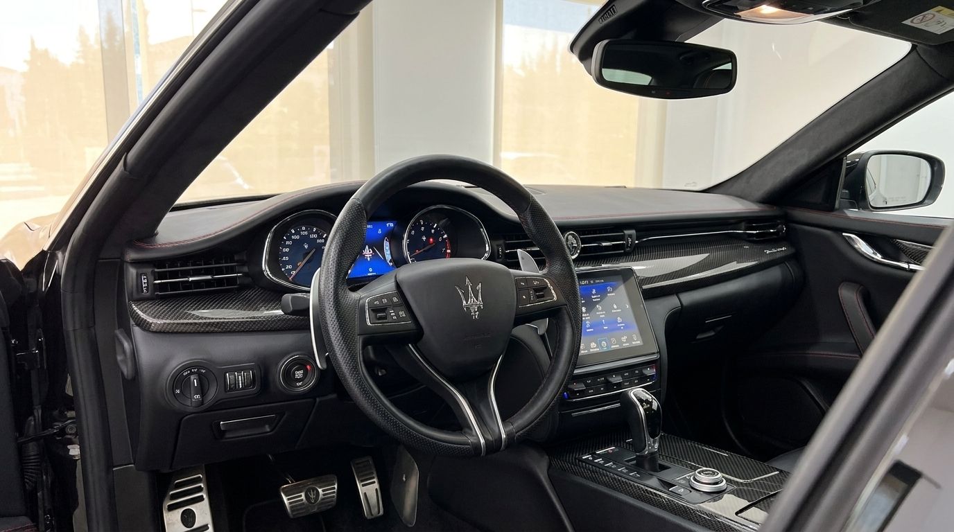 Maserati Quattroporte Sq4 Nerissimo's luxurious cockpit in Madrid, with a leather steering wheel, carbon fiber accents, and infotainment screen.