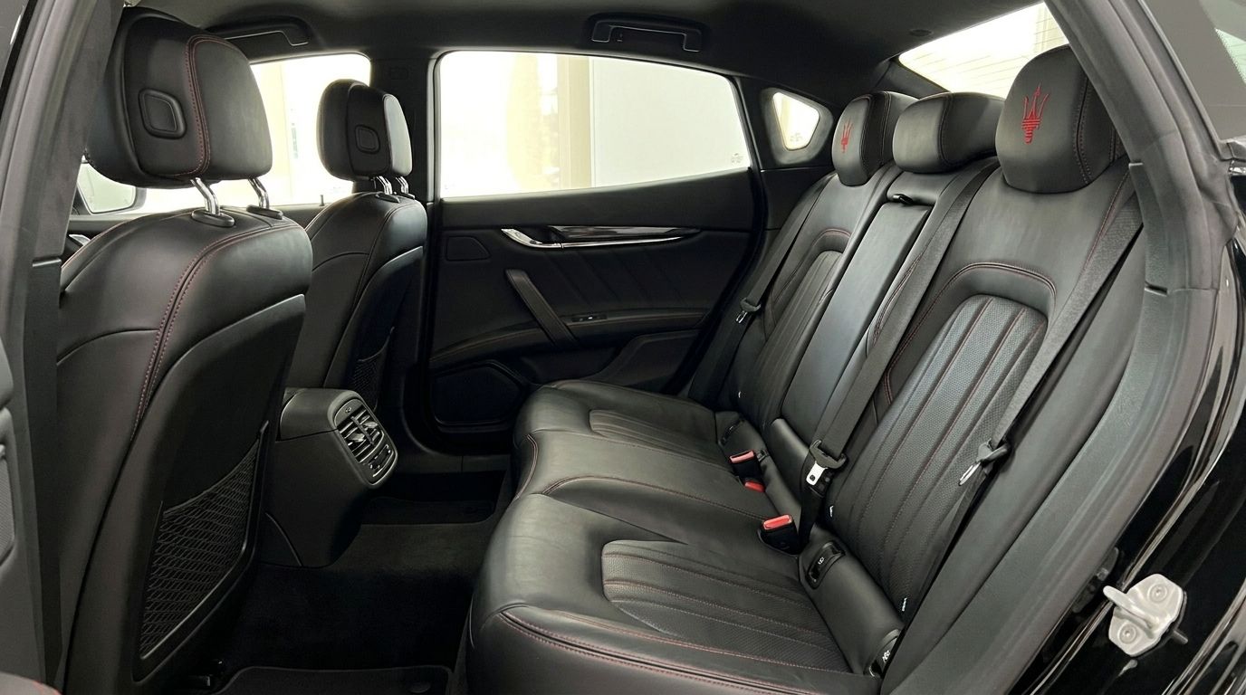 The luxurious rear black leather seats with red stitching and Maserati trident logos on the headrests of the Quattroporte Sq4 Nerissimo in Madrid.