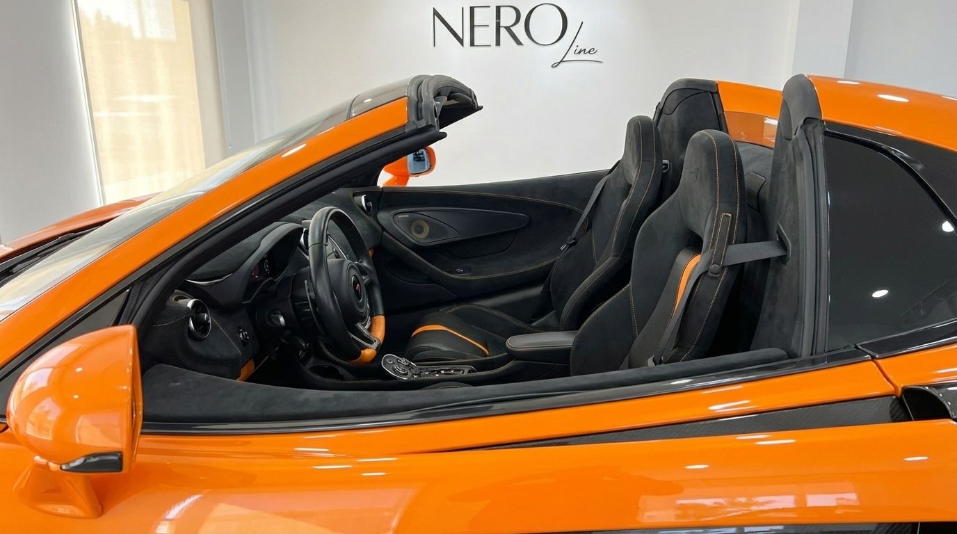 Una vista lateral del interior del McLaren 570S Spider naranja en Madrid, destacando sus asientos y salpicadero negros y naranjas.