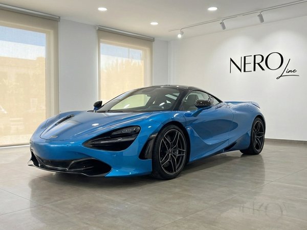 McLaren 720s — Vista frontal tres cuartos en Madrid El supercoche McLaren 720s azul cielo está aparcado en el interior, mostrando su elegante vista frontal tres cuartos en Madrid.
