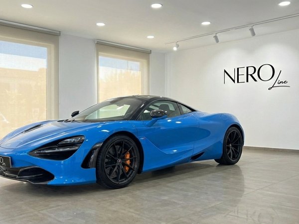 McLaren 720S — Vibrant blue supercar in Marbella A vibrant blue McLaren 720S supercar is parked in a showroom with large windows in Marbella.
