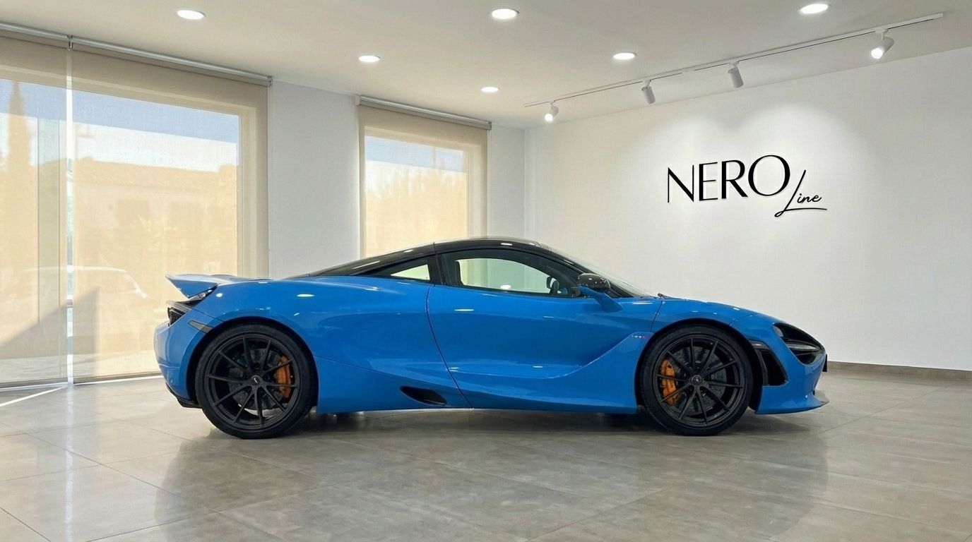 The vibrant blue McLaren 720S supercar is showcased in a side profile view inside a showroom in Marbella.