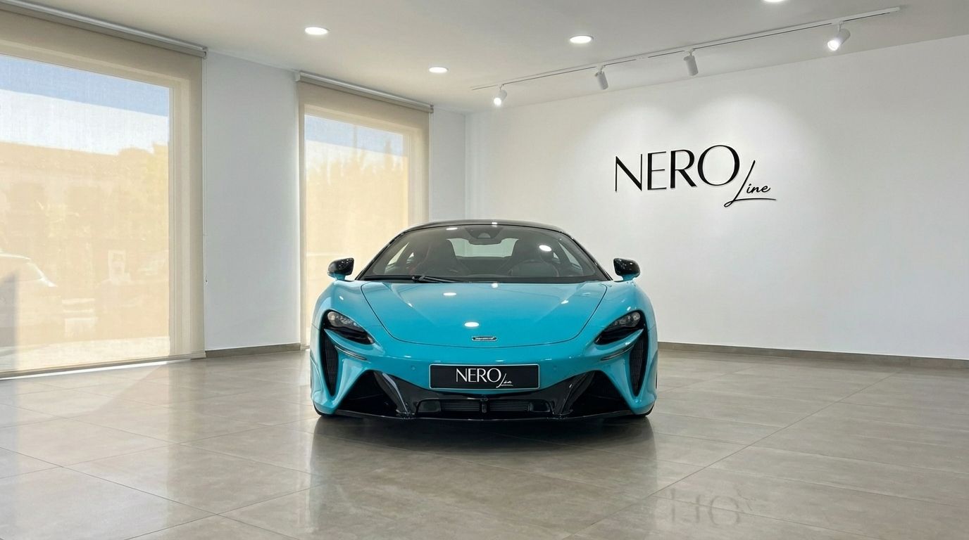 The Tokyo Cyan McLaren Artura supercar is prominently displayed from a front view inside a bright showroom in Marbella.