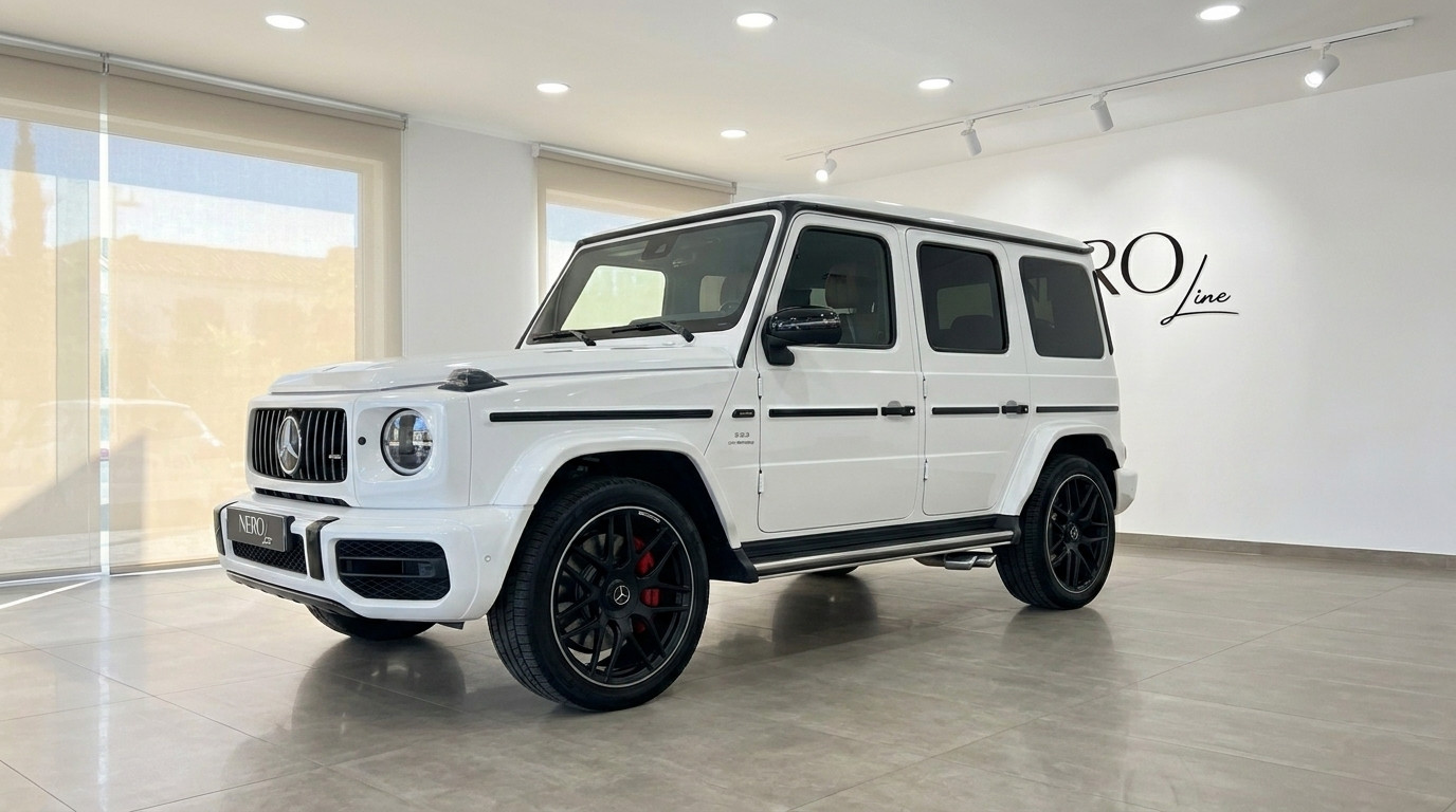 مرسيدس-AMG G 63 — سيارة دفع رباعي فاخرة في ماربيا يُعرض طراز مرسيدس-AMG G 63 الأبيض لعام 2023 من زاوية أمامية ثلاثية الأرباع في صالة عرض مشرقة في ماربيا.