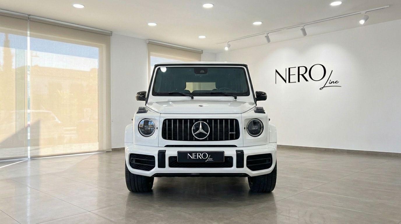 سيارة مرسيدس-AMG G 63 الدفع الرباعي البيضاء اللامعة معروضة بشكل بارز من الأمام في صالة عرض مشرقة في ماربيا.