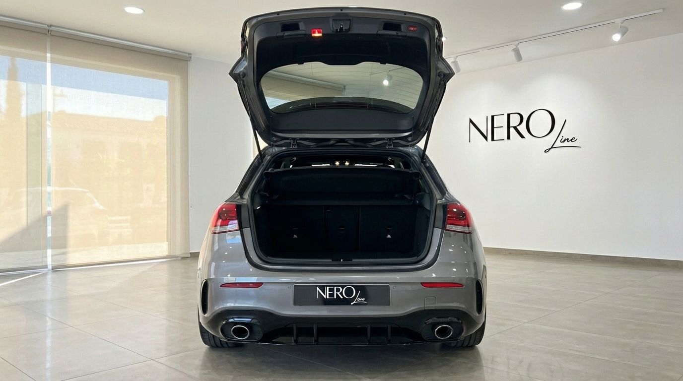 The metallic grey Mercedes-Benz A 45 AMG is shown from the rear with its trunk open, highlighting its spacious boot in Alicante.