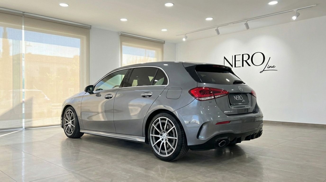 The metallic grey 2022 Mercedes-Benz A 45 AMG is showcased from a rear three-quarter view inside a luxury showroom in Alicante.