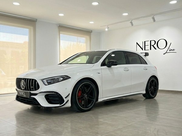 Mercedes-Benz A45s AMG — Showroom Marbella Une Mercedes-Benz A45s AMG blanche de 2021, vue de l'angle avant trois quarts, garée dans un showroom moderne à Marbella.