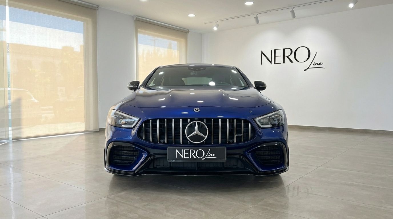 A striking front view of the blue Mercedes-Benz AMG GT 4-Door Coupe, showcased in a bright showroom in Alicante.