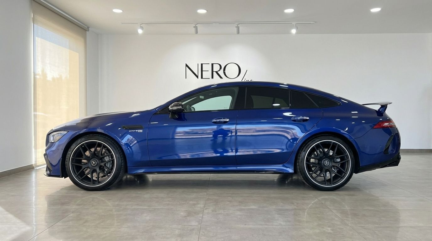 A sleek blue 2020 Mercedes-Benz AMG GT 4-Door Coupe is parked in a showroom, viewed from its side profile in Alicante.